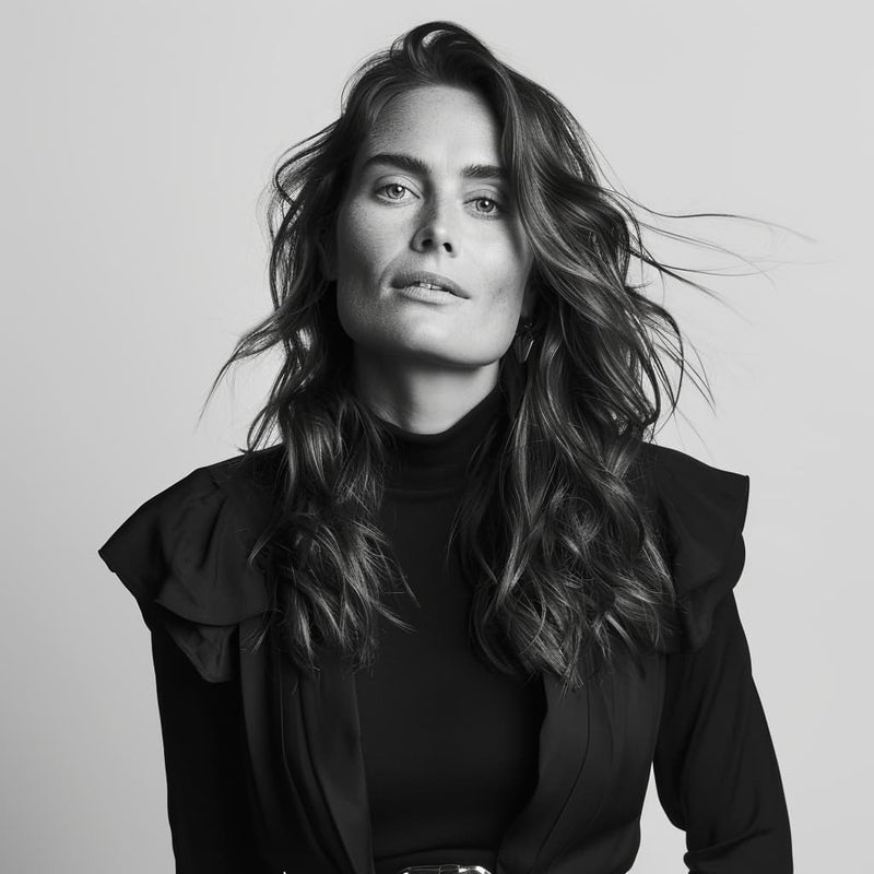 Olivia Haugen, Norwegian jewelry designer, in a black turtleneck, with a confident expression, in a black and white studio portrait.